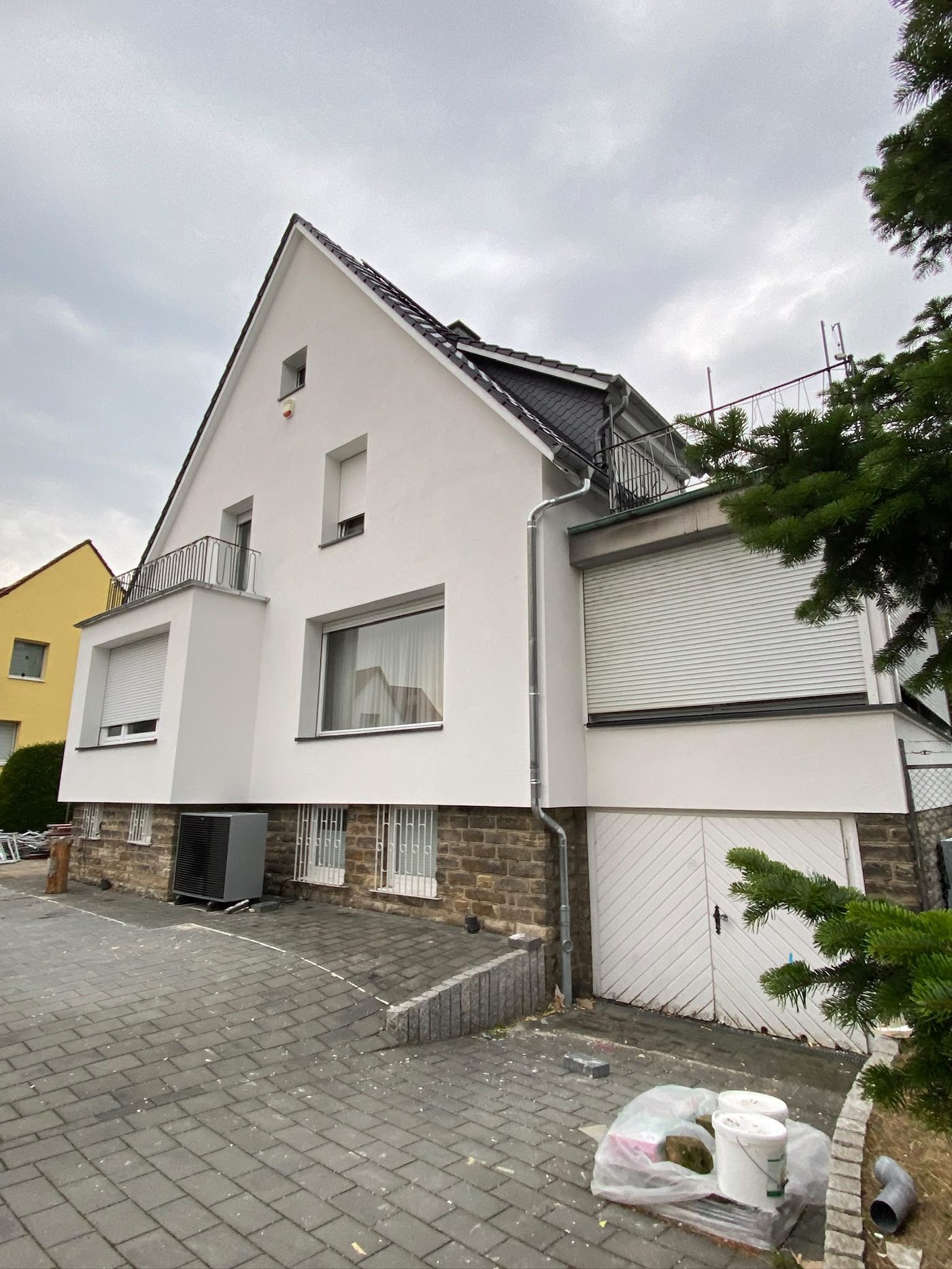 Seitenansicht mit Garage und gepflastertem Hof